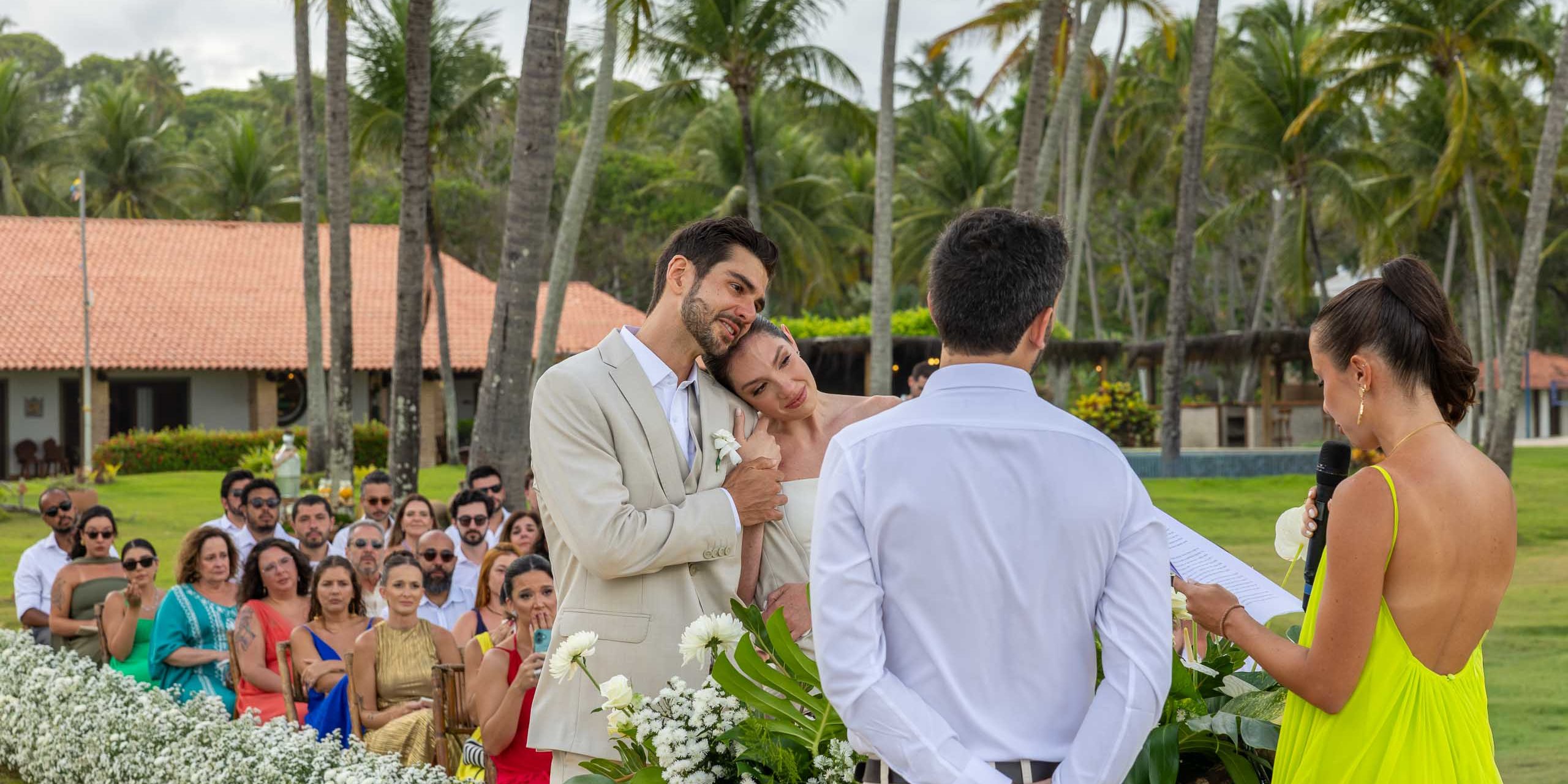 Couple listening to a reading during an outdoor wedding ceremony.