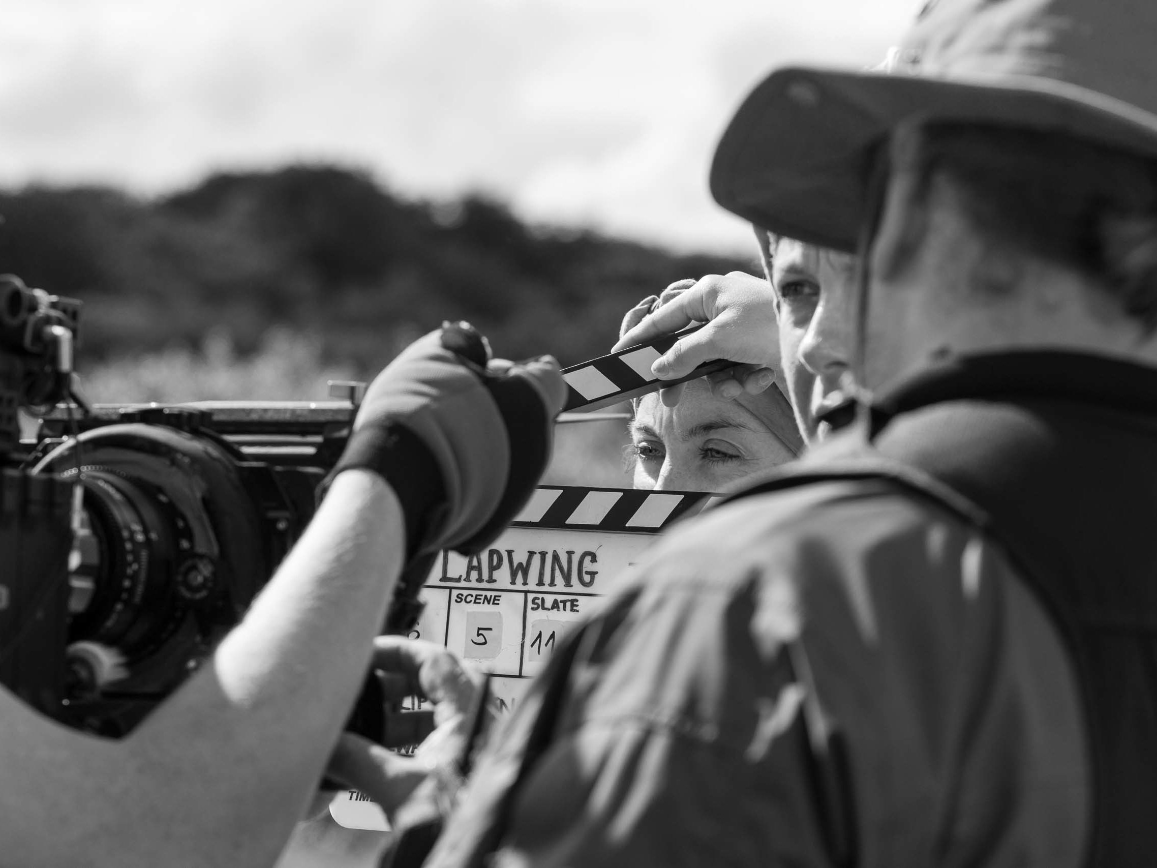 Film crew operating a cinema camera and clapperboard during a film production.